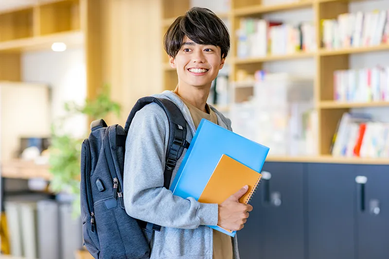 大学の図書館で学ぶ学生